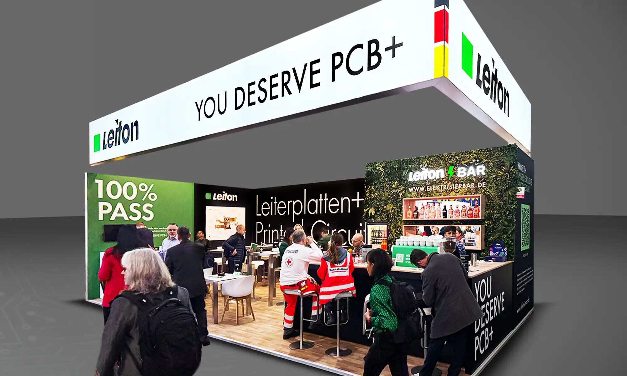 A photo of the Leiton exhibition booth showcasing the slogan "YOU DESERVE PCB+," a "100% PASS" section, and a green, plant-themed "Leiton Bar." The booth includes tables, seating, and display areas designed for visitor interaction. Some visitors are also to be seen.